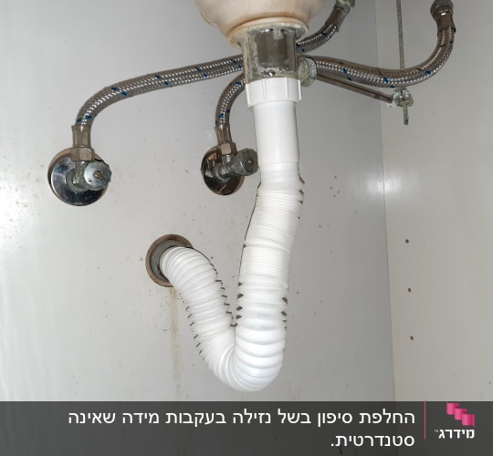 צינור ניקוז לבן מתחת לכיור עם חיבורים